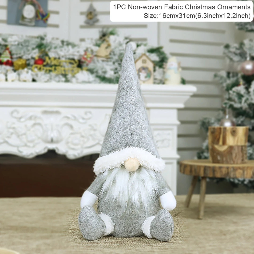 Silver fabric Christmas gnome with a pointed hat and white beard sits before a decorated fireplace beside a 16 × 31 cm label.