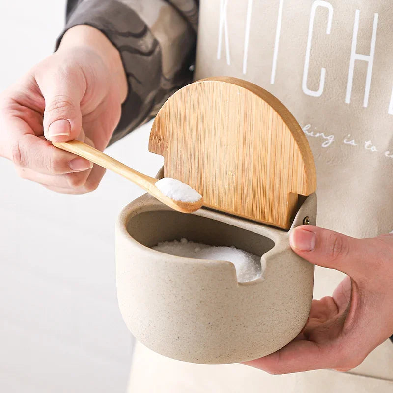 Ceramic salt cellars with bamboo lids and wooden tray, angled studio shot
