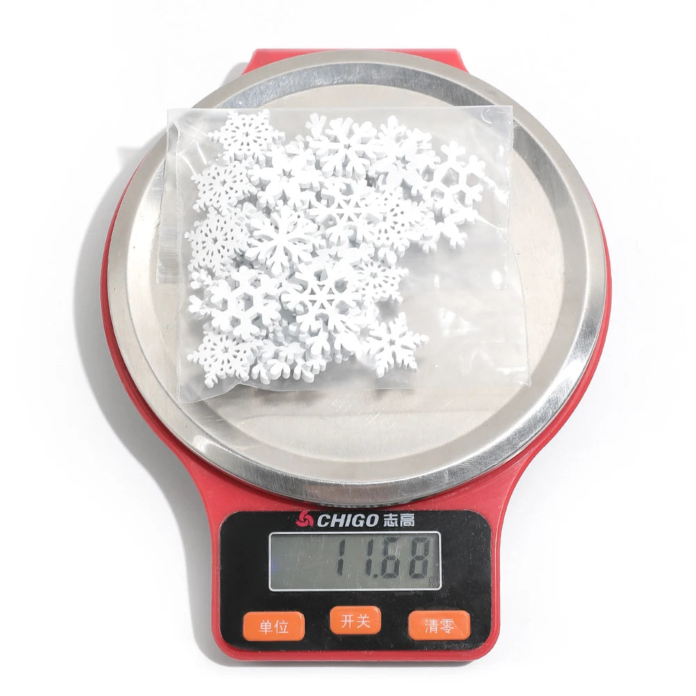 A clear bag of white wood snowflake ornaments rests on a red digital scale displaying 11.68 against a white background.