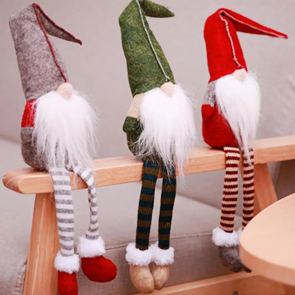 Three Christmas gnomes with bent gray, green, and red hats sit on a wooden chair rail with striped legs dangling.