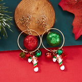 Snowflake drop earrings with gold-tone rings, red and green glitter balls, bells and candy cane charms rest beside wood on red and teal backgrounds.