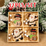 Wooden Santa and snowman Christmas ornaments with white-beaded cords fill a divided box beneath a 12-piece set label among frosted branches.