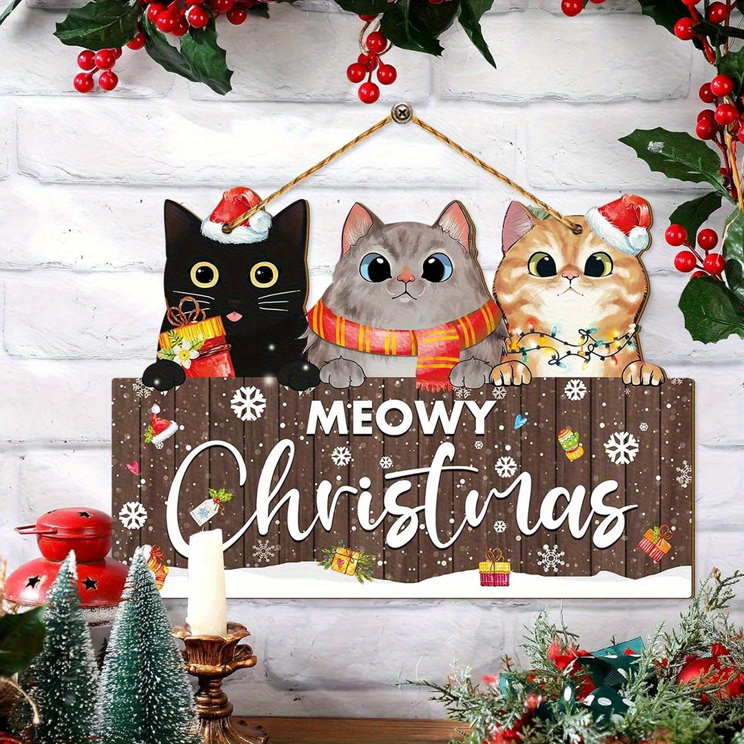 Brown Meowy Christmas hanging sign with three cats hangs against white brick, surrounded by red berries, miniature trees, and a candle.