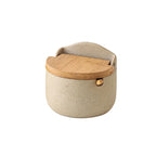 Single ceramic salt cellar with bamboo lid on a plain background