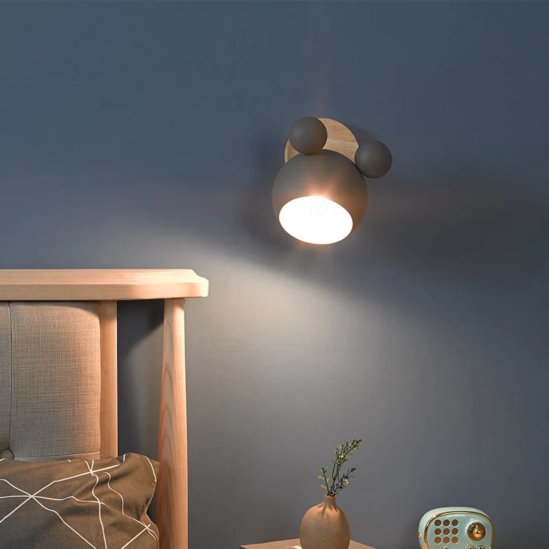 Gray wall lamp lit warm at night on a dark blue bedroom wall