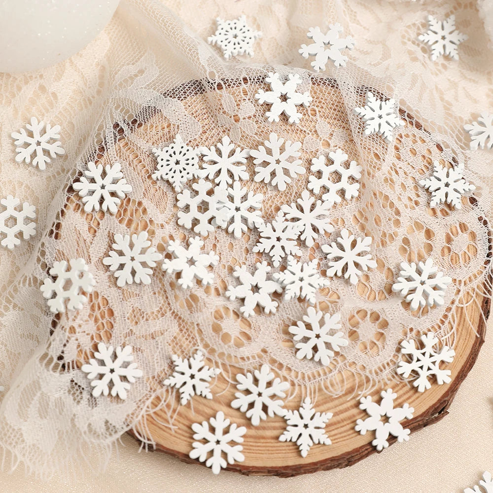 White wood snowflake ornaments in assorted designs lie scattered across cream lace draped over a round wood slice.