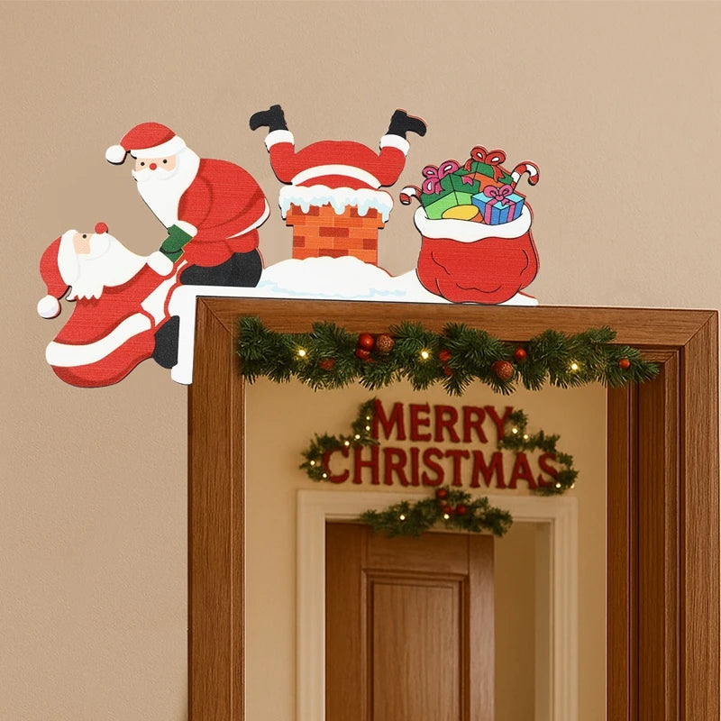 Red Santa door corner decoration with a snowy chimney and gift sack sits above a wooden doorway trimmed with garland.