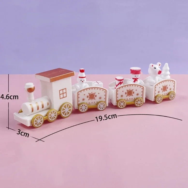 White Christmas train decoration with gold wheels and three connected carriages on pink, labeled 19.5 cm long, 4.6 cm high, and 3 cm wide.