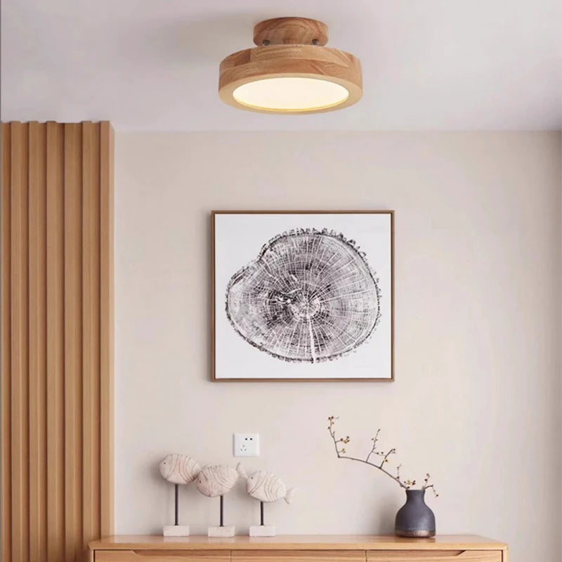 Wood flush mount ceiling light near a wood dresser with framed wall art and ceramic fish figurines