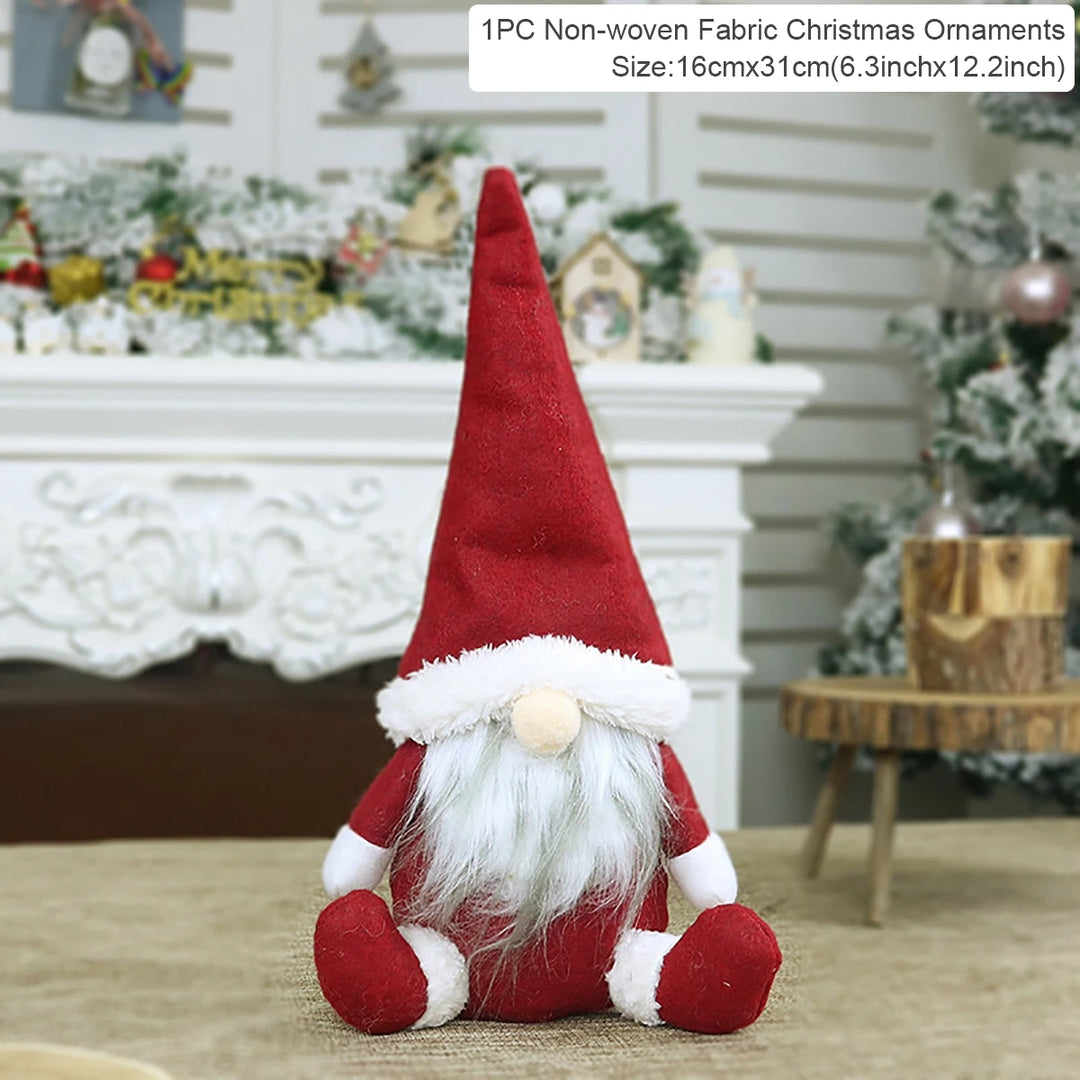 Red fabric Christmas gnome with a pointed hat and white beard sits before a decorated fireplace beside a 16 × 31 cm label.