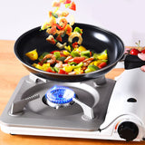 Portable stove with a frying pan containing colorful vegetables and shrimp.