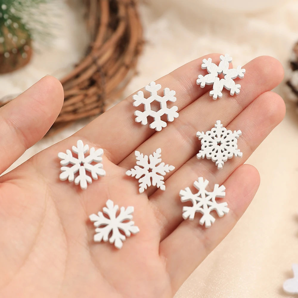 Seven white wood snowflake ornaments in different patterns rest in an open hand against a softly blurred cream background.