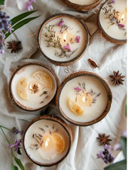 Coconut shell candles with lemon slices, lavender and star anise on white linen