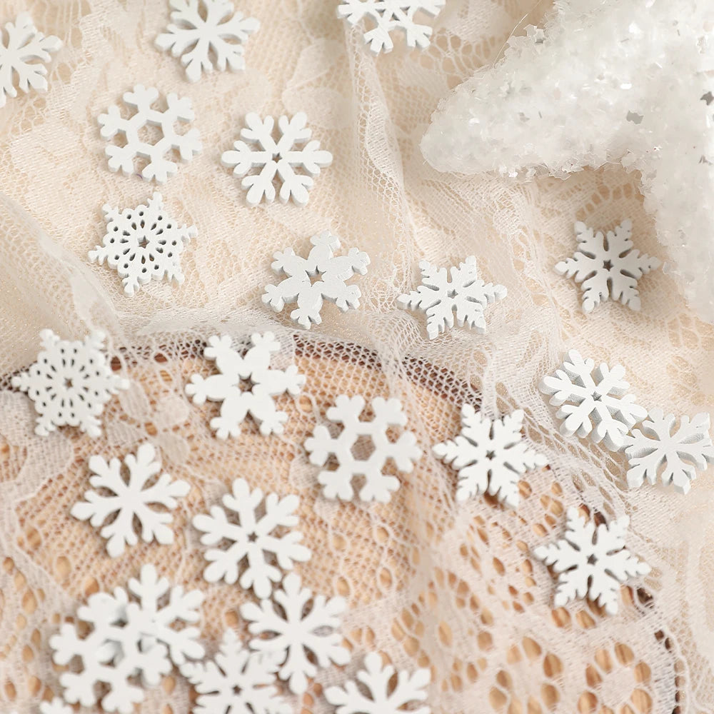 White wood snowflake ornaments rest on cream lace beside a partially visible glittery white star decoration.