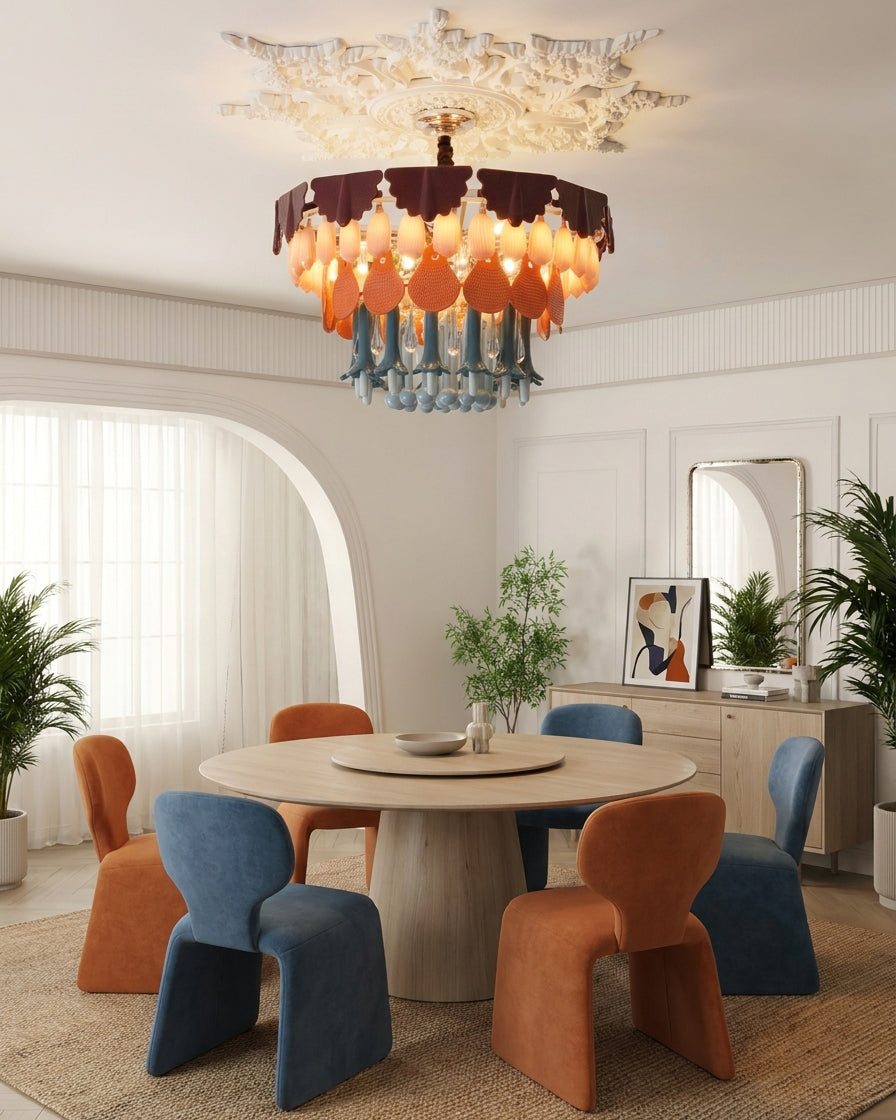 Modern dining room with colorful chairs and a chandelier.