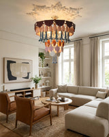 Modern living room with a chandelier, sofa, and armchairs.