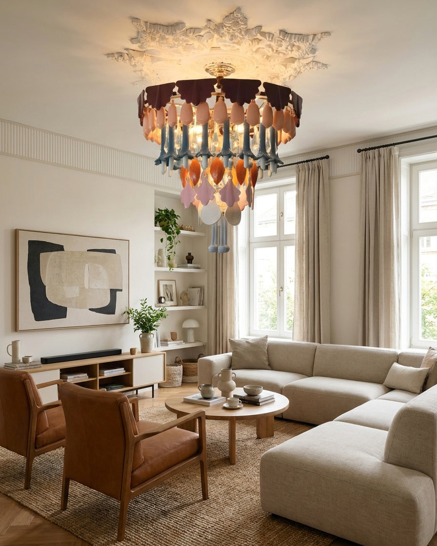 Modern living room with a chandelier, sofa, and armchairs.