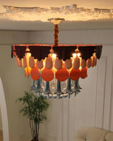 Decorative chandelier with orange and white shades in a room setting.