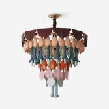 A multicolor decorative chandelier with a gold-toned metal frame, featuring layered tiers of scalloped dark burgundy and dusty rose shades, peach-colored teardrop ornaments, teal and orange hanging accents, and pink and gray leaf-shaped ornaments, shown against a plain white background.