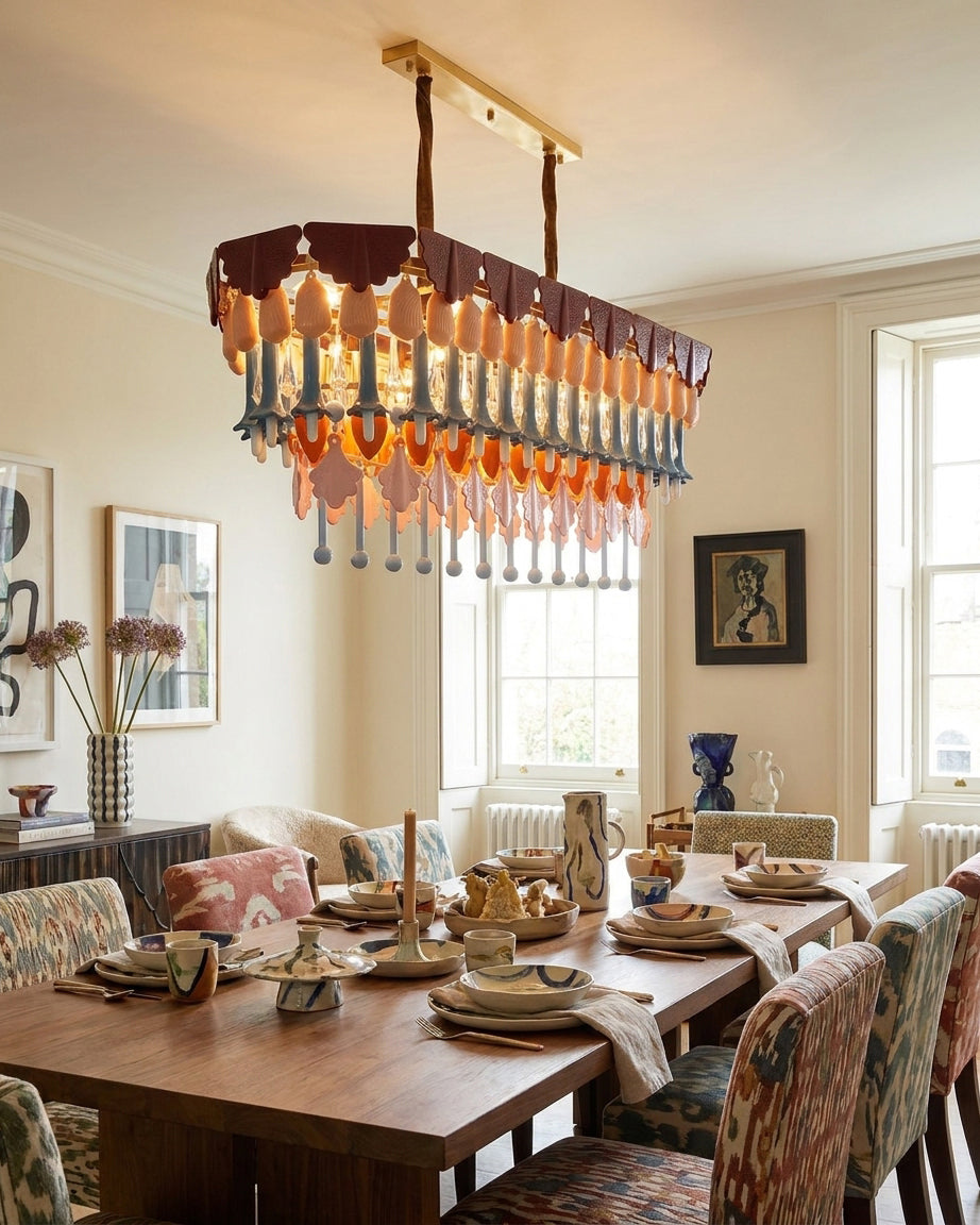 Dining room with a modern chandelier, wooden table, and chairs.