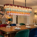 Dining room with a colorful chandelier, table set for dinner, and decorative wall art.
