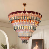 Multicolored chandelier hanging in a room with a painting and plant.