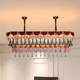 Colorful chandelier hanging in a room with white walls and a staircase.