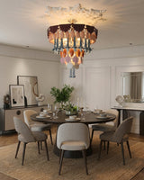 Dining room with a round table, chairs, and a chandelier.