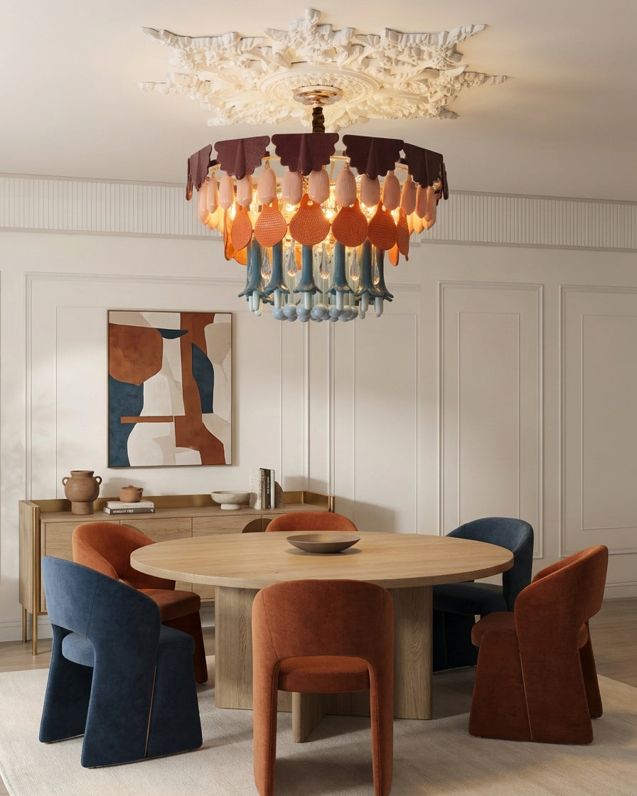 Dining room with a modern chandelier, round table, and colorful chairs.