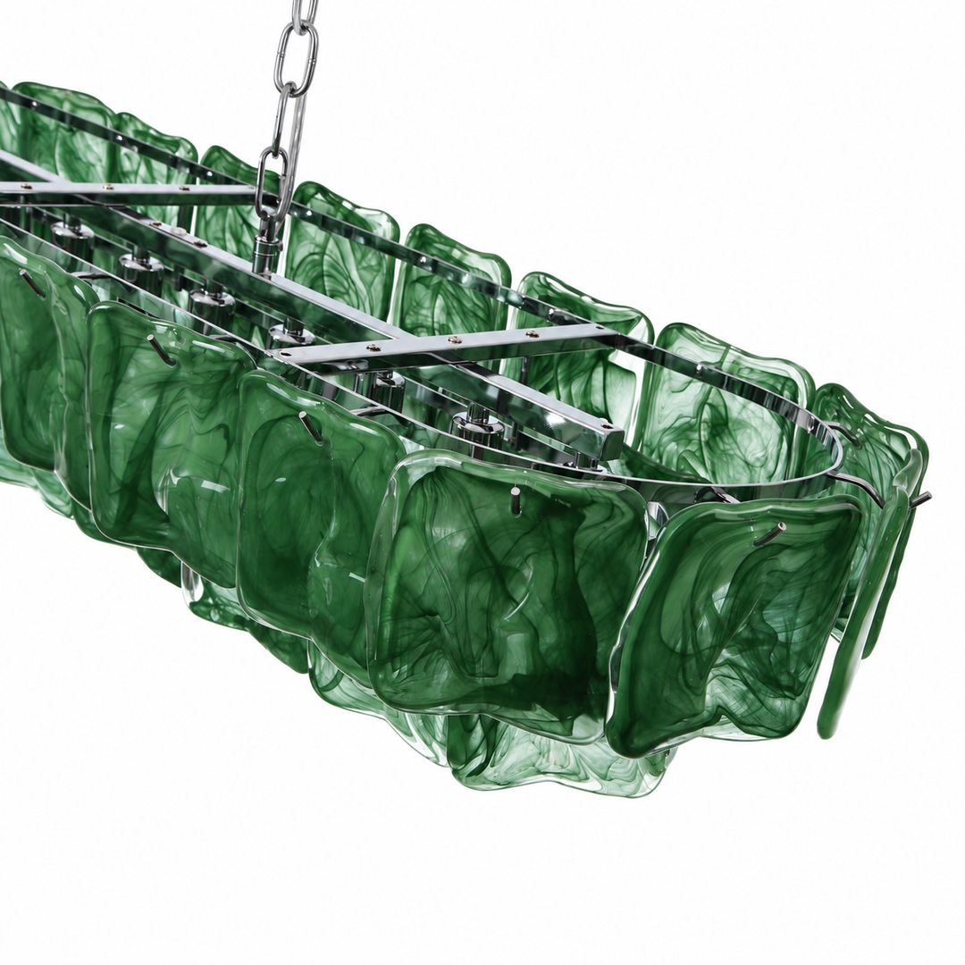 A close-up of the linear chandelier shows dark green rippled glass panels and a silver metal frame against a white background.