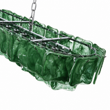 A close-up of the linear chandelier shows dark green rippled glass panels and a silver metal frame against a white background.