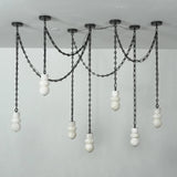 A modern multi-light linear chandelier with black metal chains and spherical white glass shades, suspended from a ceiling against a plain light gray wall.