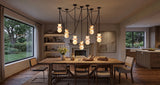 A modern multi-light pendant chandelier with multiple black chains and glowing frosted glass globes, hanging over a wooden dining table in a warm, contemporary dining room.