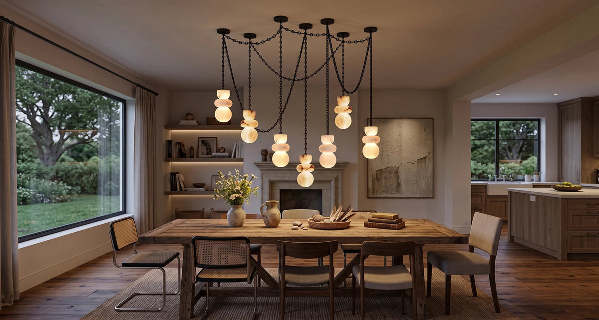 A modern multi-light pendant chandelier with multiple black chains and glowing frosted glass globes, hanging over a wooden dining table in a warm, contemporary dining room.