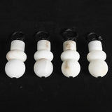 Four alabaster chandelier shades with natural cream veining stand upright against a black background.
