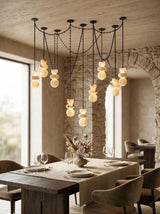 Dining room with a modern chandelier, wooden table, and chairs.