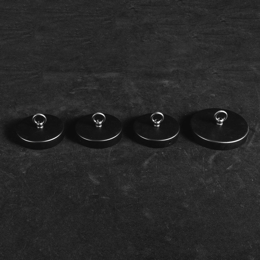 Four black round ceiling mounts in graduated sizes with metal loops for the alabaster chandelier, on a dark background.