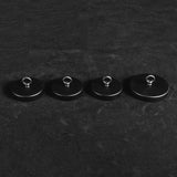 Four black round ceiling mounts in graduated sizes with metal loops for the alabaster chandelier, on a dark background.