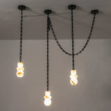 Alabaster chandelier with three glowing, veined stone shades suspended at staggered heights beneath black chains against a gray wall.