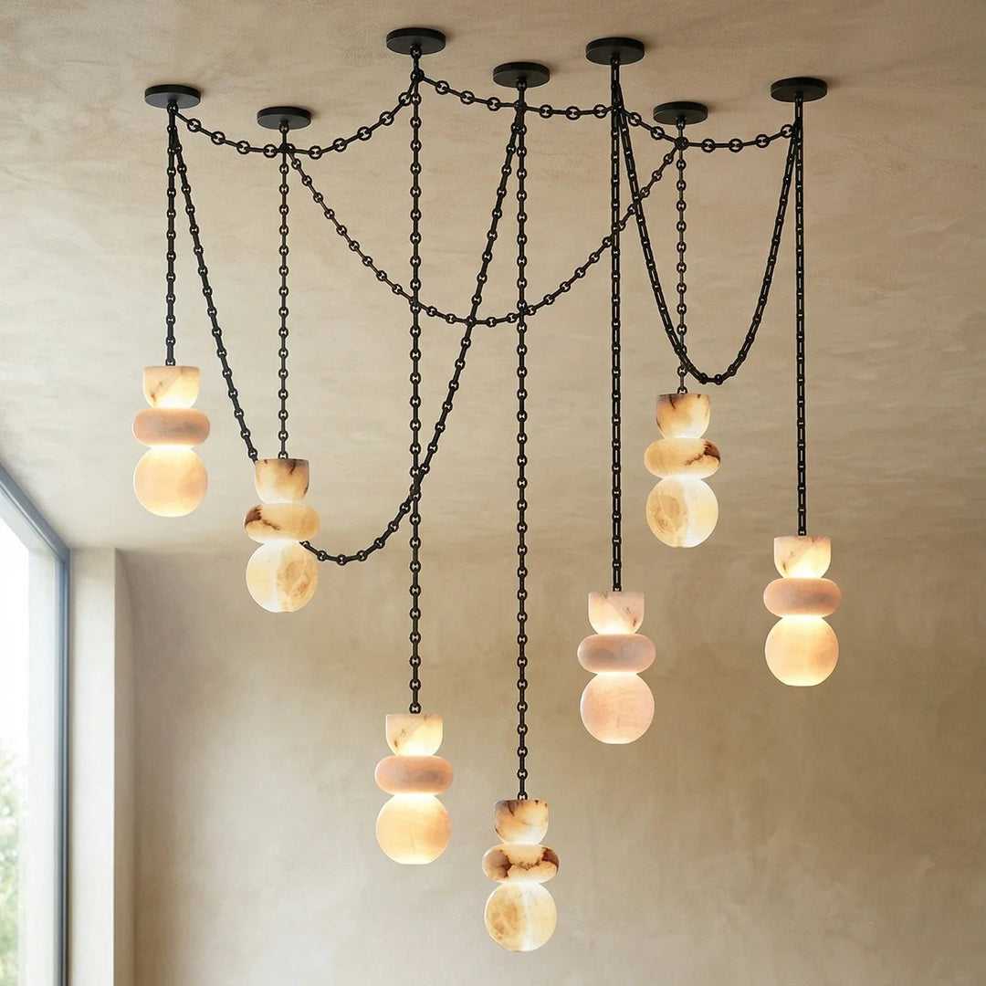 Modern chandelier with hanging lights in a room with a window.