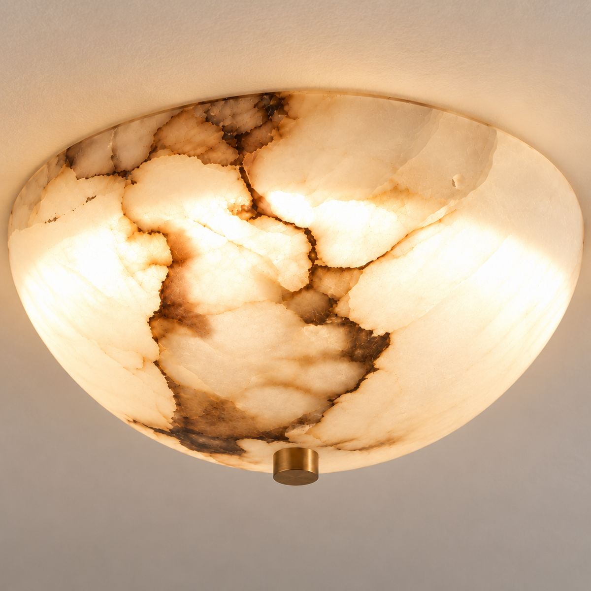 A flush-mount ceiling light fixture made from polished natural onyx, featuring a warm glowing oval shade with distinctive brown and cream veining, mounted on a white ceiling with a small gold brass finial.