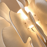 Close-up of the floor lamp’s layered cream ceramic shades, showing curved edges, fine ridged texture, exposed screws, and warm light between panels.