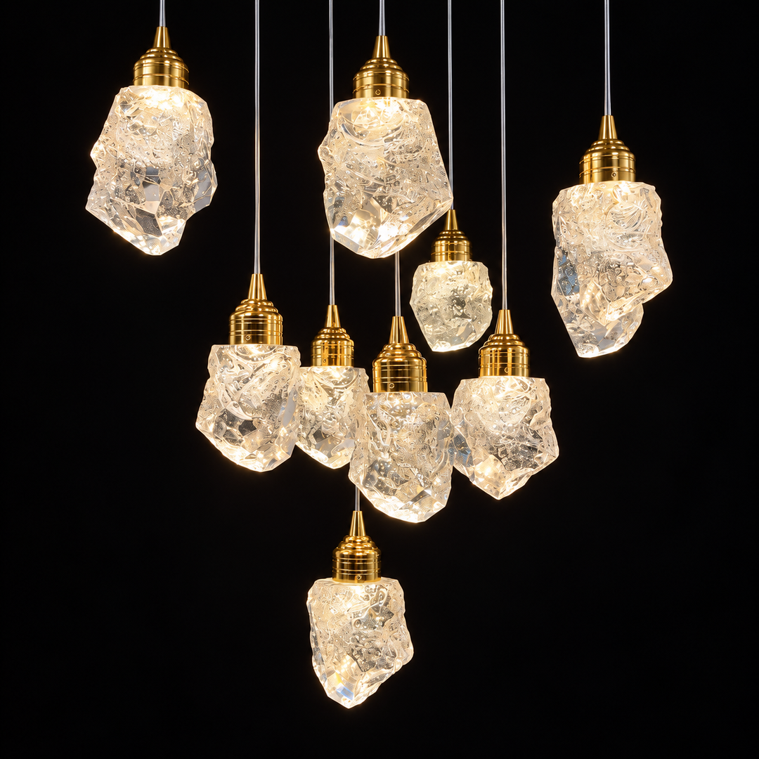 A chandelier with glowing clear crystal shades and polished gold fittings forms a cascading cluster against a black background.