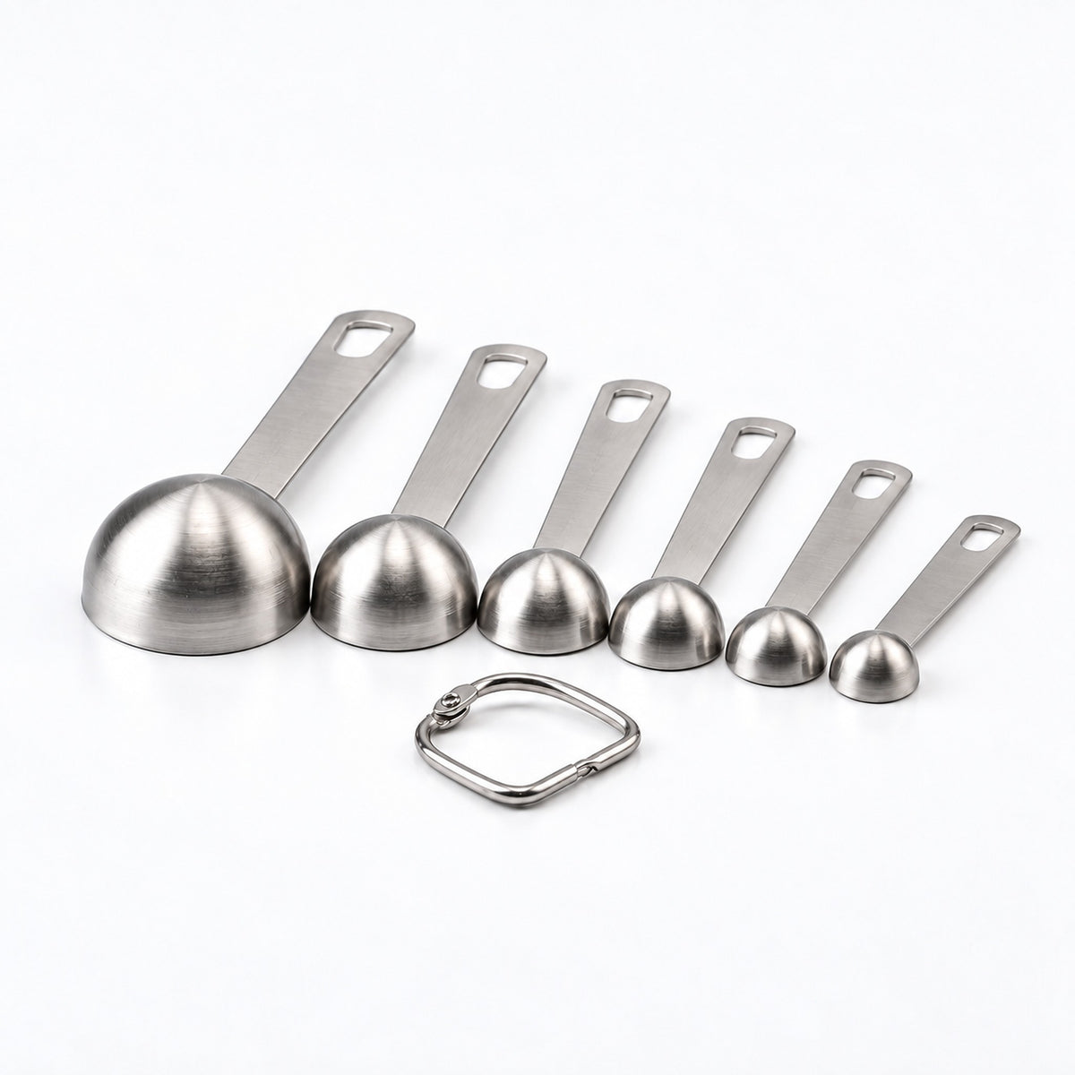 Undersides of six stainless-steel measuring spoons with their removable connecting ring.