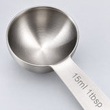 Close-up of a stainless-steel measuring spoon bowl, brushed handle and capacity engraving.