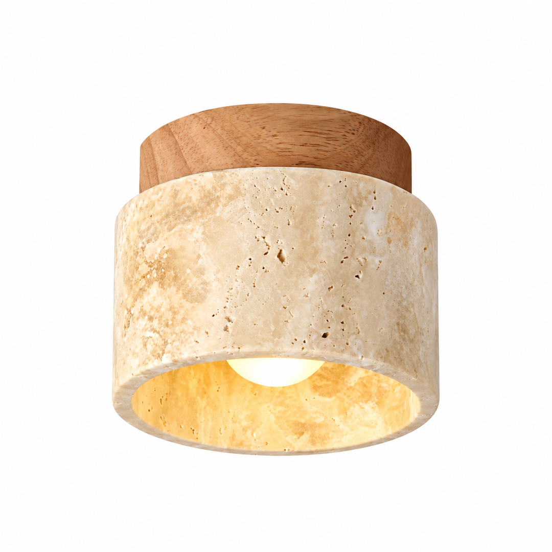 A modern semi-flush mount ceiling light fixture featuring a textured beige travertine stone cylinder shade with a warm yellow-gold interior, a natural wood top cap, and a glowing light bulb inside, shown on a solid white background.