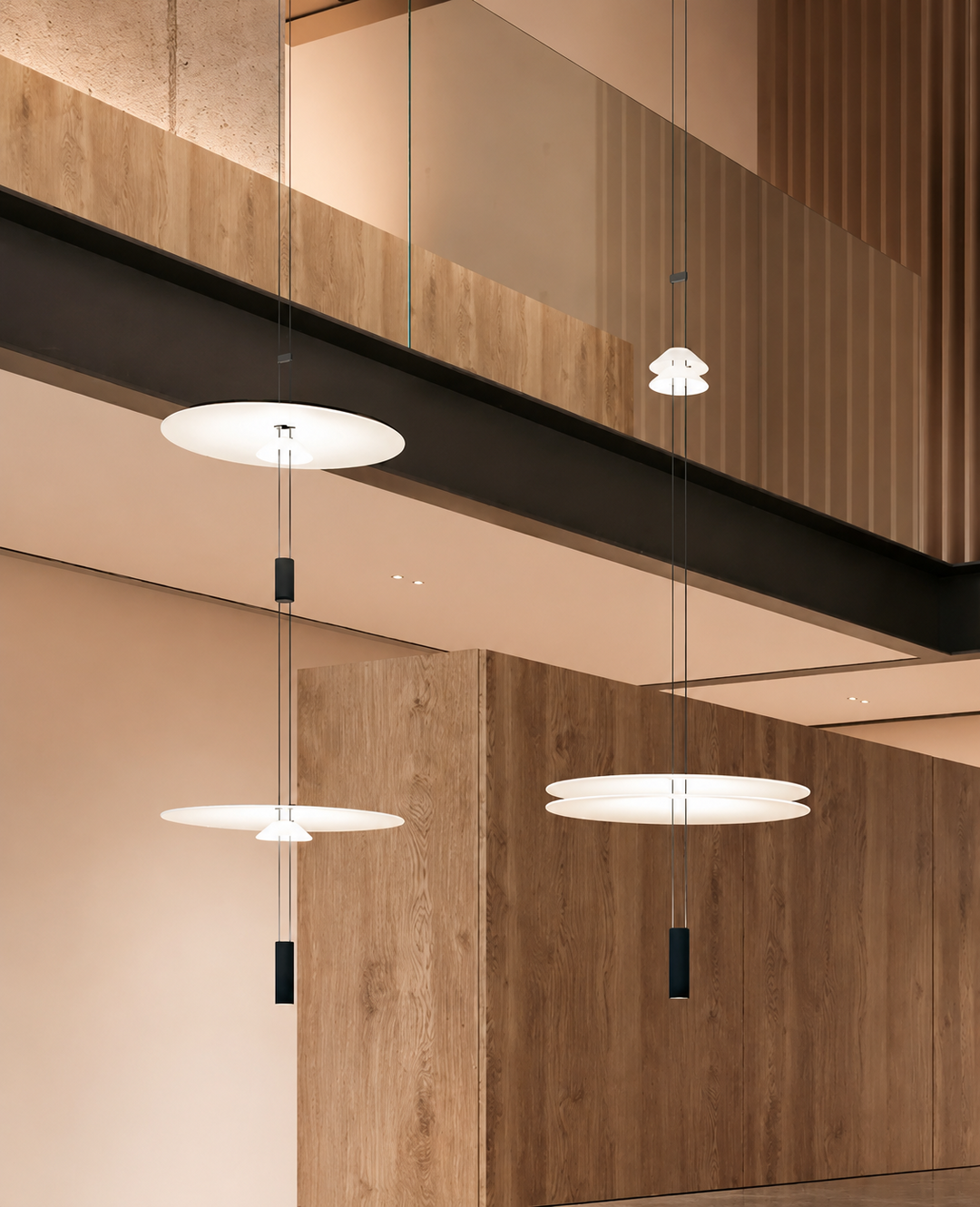 Modern pendant lights hanging from a ceiling with wooden paneling.