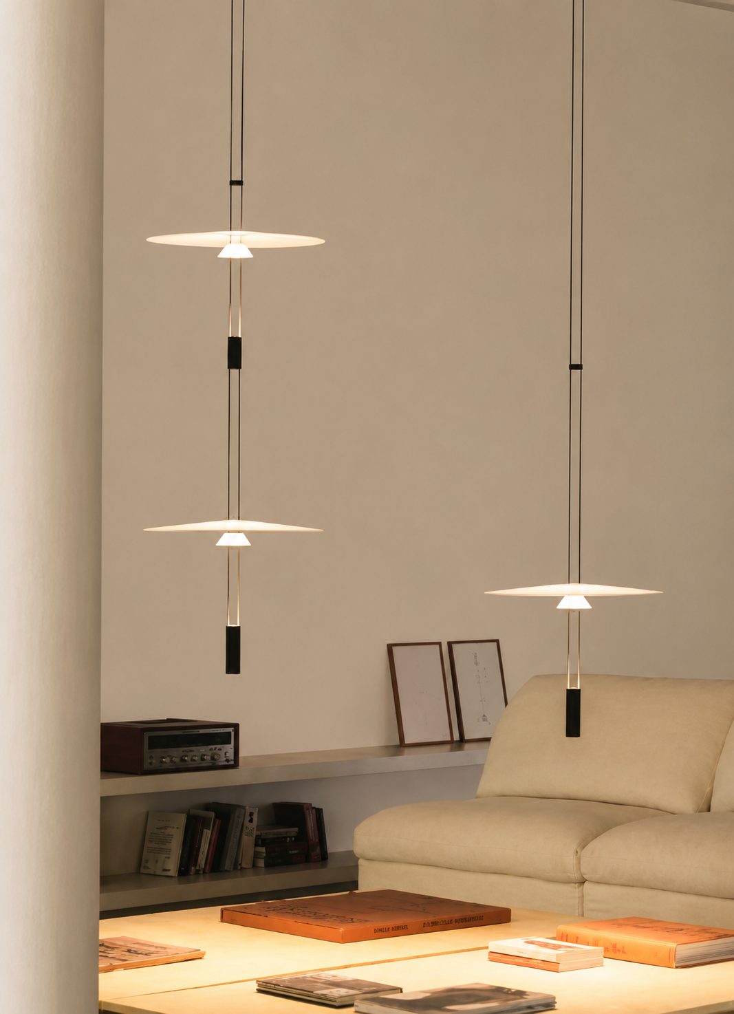 Modern pendant lights hanging above a living room with a beige sofa and decor.