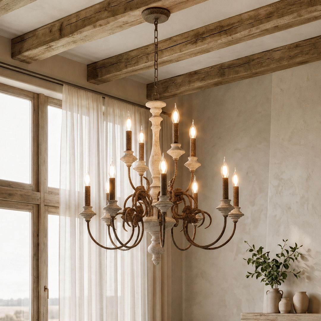 A rustic multi-light chandelier with distressed metal arms and cream-colored turned wood candle-style shades, hanging in a bright room with exposed wooden ceiling beams, sheer curtains, and a small plant on a console table.