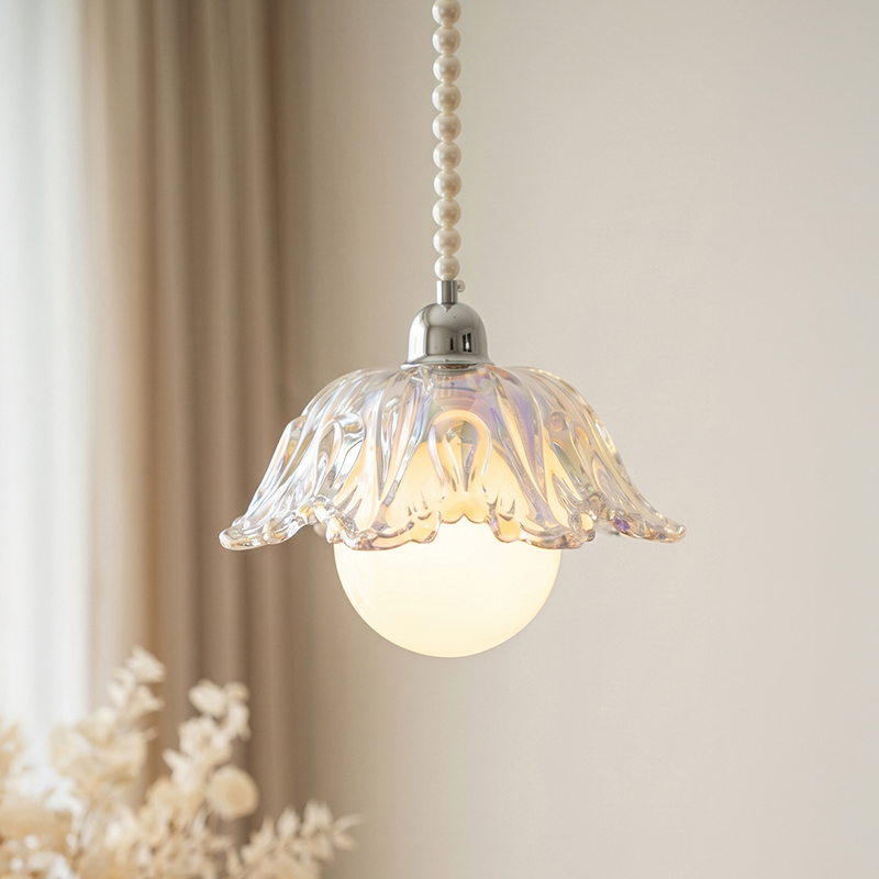 Decorative pendant light with floral glass shade on a neutral background